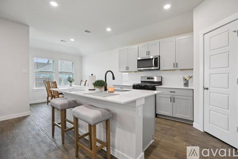 A kitchen with white cabinets and a bar area.