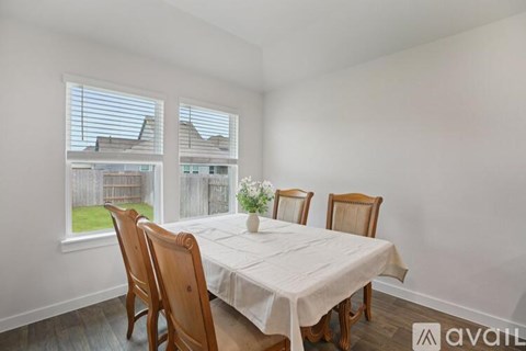 A dining room with a table and chairs.