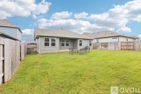 A house with a fenced backyard and a patio table.