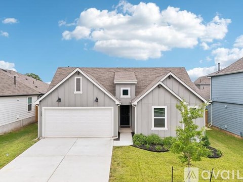 A house with a garage and a driveway in front of it.