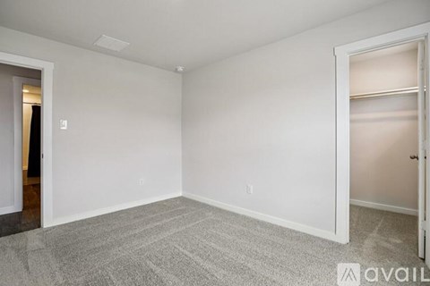 A room with a carpeted floor and two doors.
