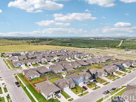 A suburban neighborhood with houses and cars parked on the streets.