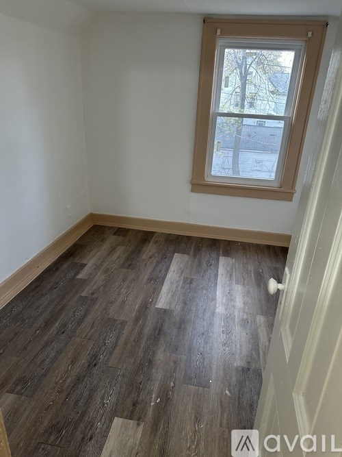 A room with a window and wooden flooring.