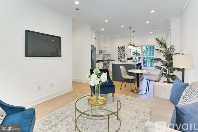 A living room with a blue chair and a glass coffee table.