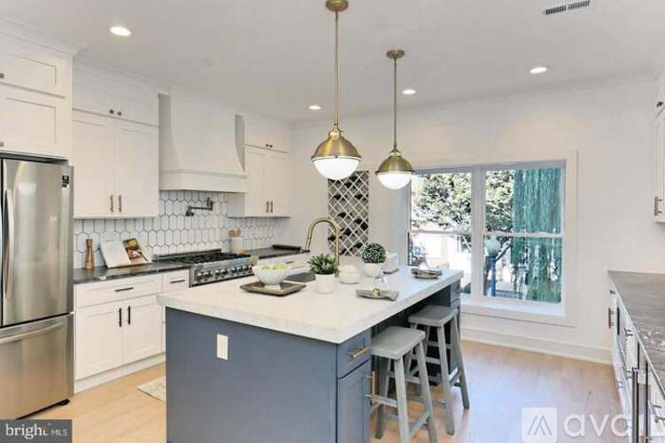A kitchen with a large island and a refrigerator.