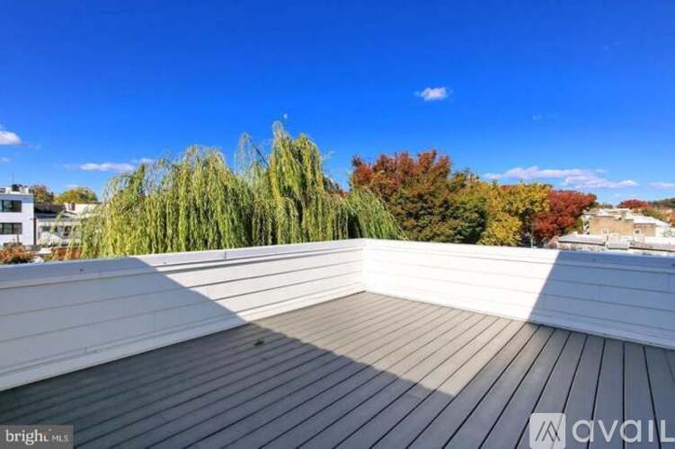 A wooden deck overlooks a tree-filled landscape.