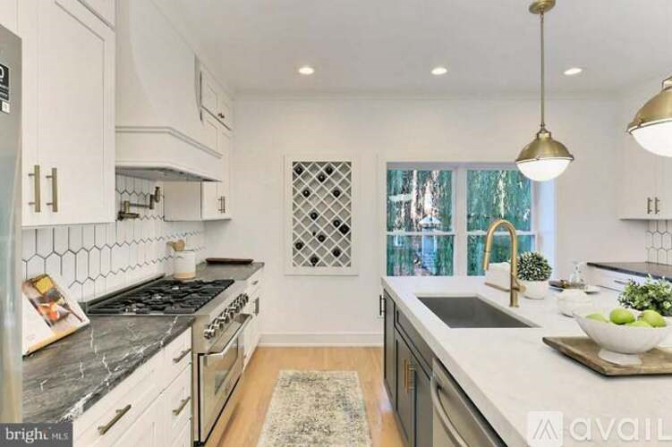 A kitchen with a black and white tiled backsplash and a window with a diamond pattern.