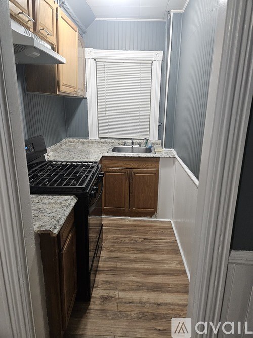 A kitchen with a stove top oven and a sink.