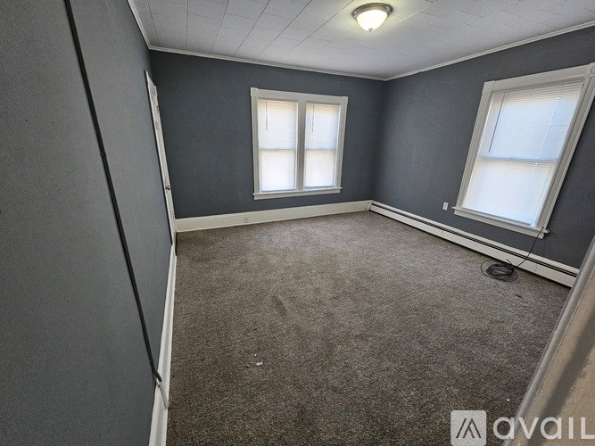 A room with grey walls and carpeted floor.