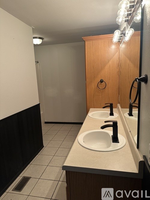A bathroom with a sink, mirror, and light.