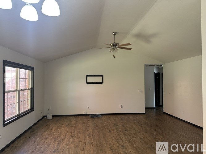 A room with a ceiling fan and a picture frame on the wall.