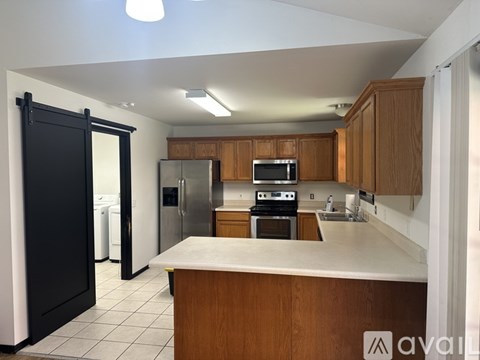 A kitchen with wooden cabinets and a black fridge.