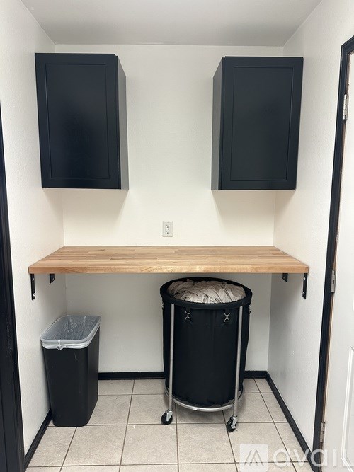 A small kitchen with a wooden counter and two black cabinets.