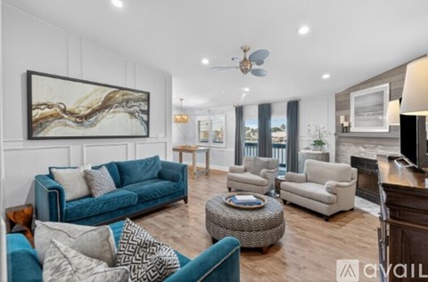 A living room with a blue couch and a painting on the wall.