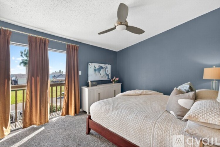 A bedroom with a large bed and a ceiling fan.