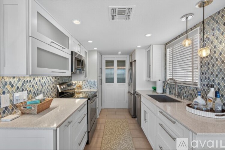 A kitchen with white cabinets and a tiled backsplash.
