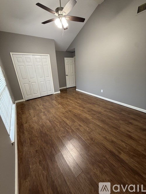 A room with wooden flooring and a ceiling fan.