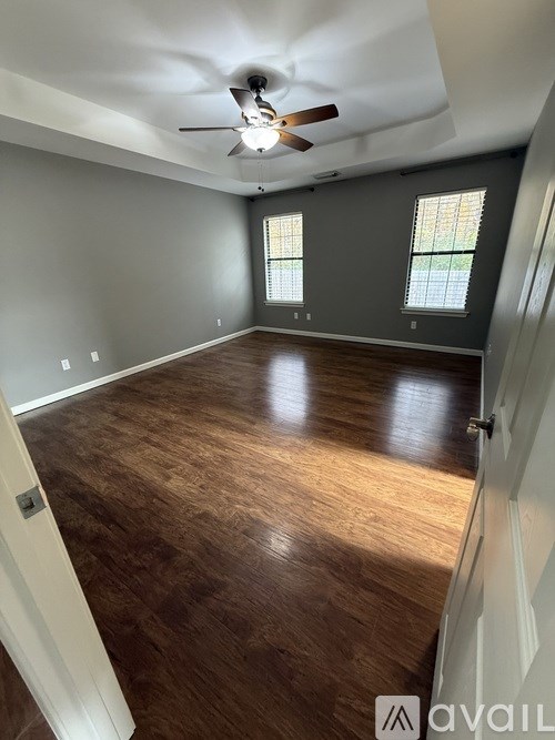 A room with wooden floors and a ceiling fan.