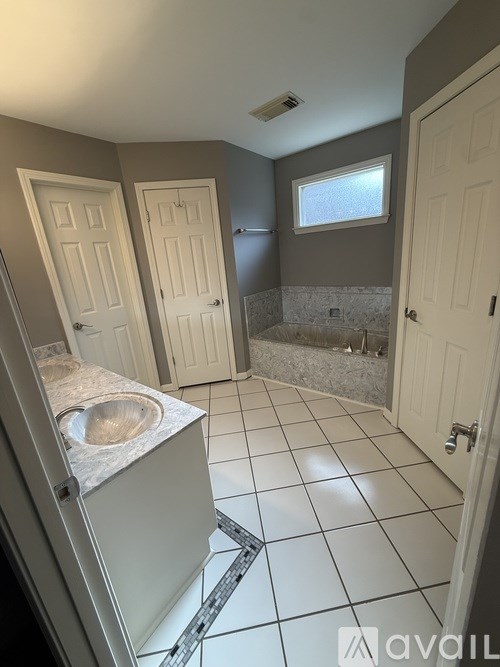 A bathroom with a white sink and tiled floor.