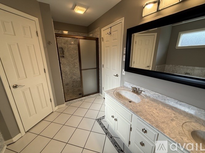 A bathroom with a sink, mirror, and tiled floor.