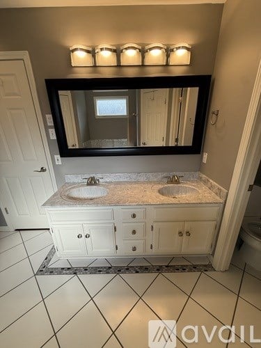 A bathroom with a vanity and a mirror above it.