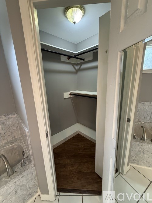 A white door is open to a small bathroom.