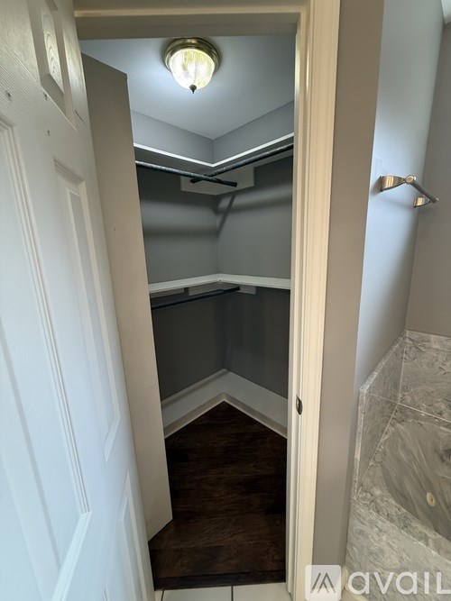 A white door opens to a small room with a skylight.