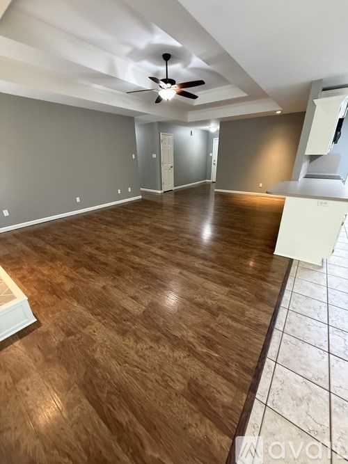 A room with wooden flooring and a ceiling fan.