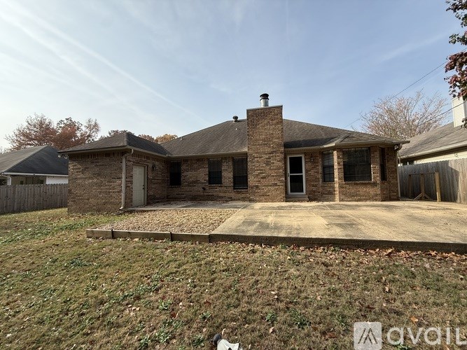 A house with a brick chimney and a stone wall is for sale.