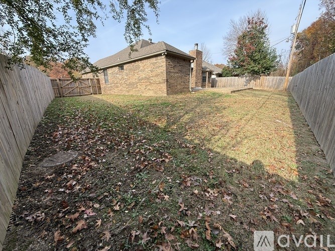 A backyard with a wooden fence and a house in the background.
