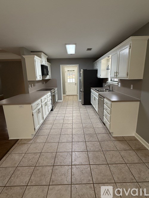A kitchen with white cabinets and a tiled floor.