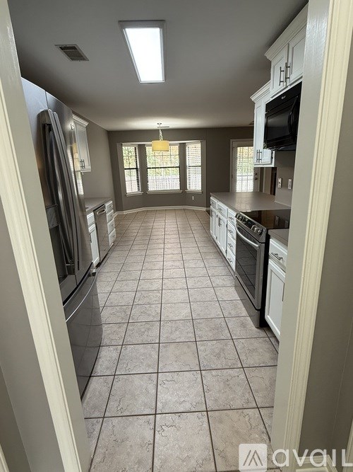 A kitchen with tile flooring and stainless steel appliances.