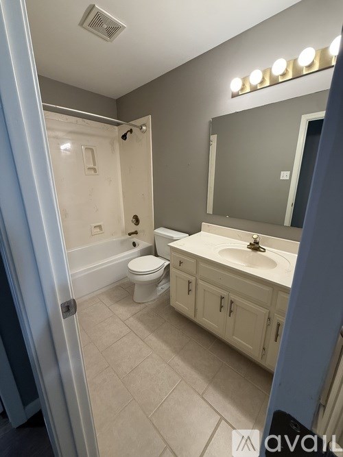A bathroom with a toilet, sink, and mirror.