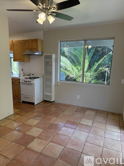 A kitchen with a tile floor and a ceiling fan.