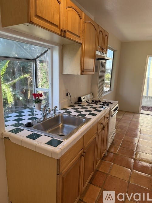 A kitchen with wooden cabinets and a checkered tile backsplash.