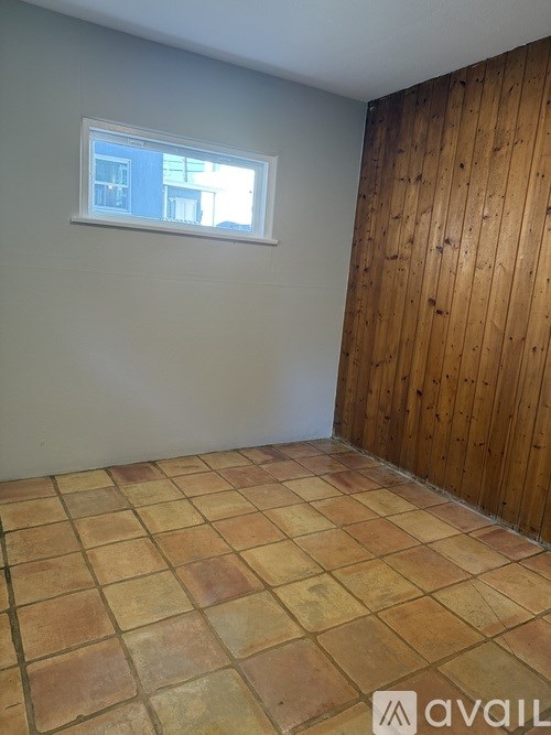 A room with a tiled floor and a wooden wall.