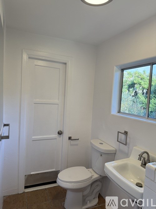 A white toilet and sink in a small bathroom.