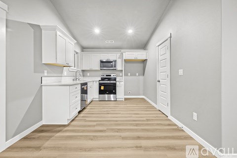 A kitchen with white cabinets and appliances.