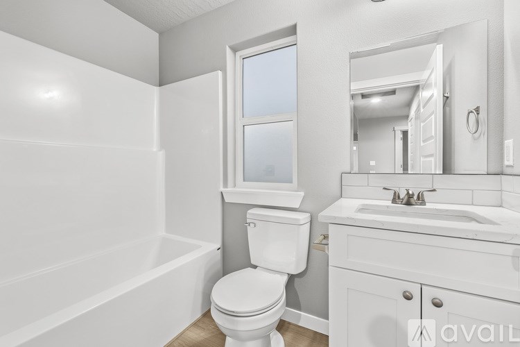 A white bathroom with a toilet, sink, and bathtub.