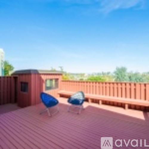 A wooden deck with two chairs and a table.