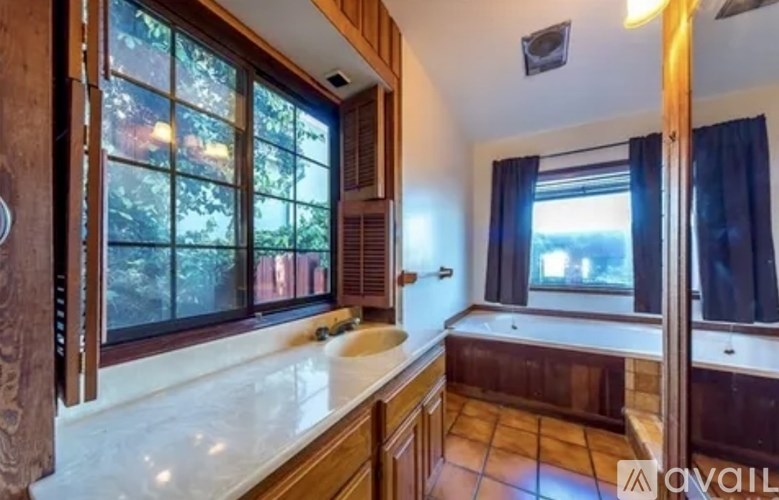 A kitchen with a marble countertop and wooden cabinets.