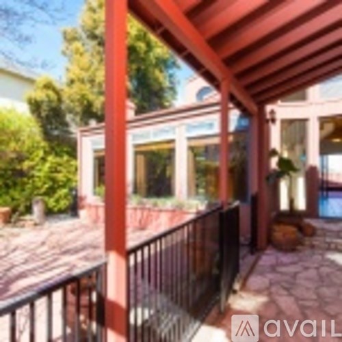 A patio with a black railing and a red roof.