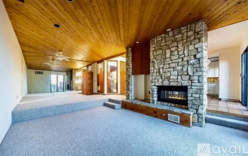 A stone fireplace is built into a wooden wall.