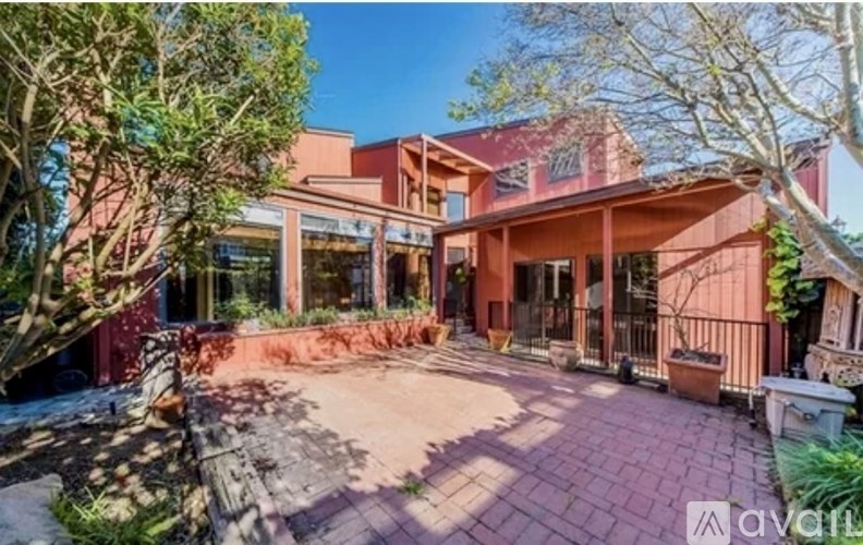 A house with a red brick patio and a black gate.