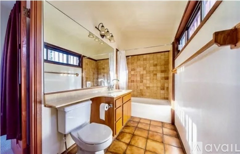 A bathroom with a toilet, sink, and tiled floor.