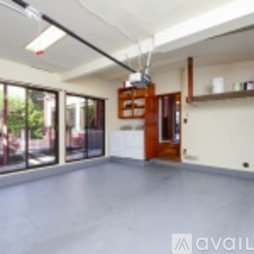 A spacious room with a sliding glass door and a wooden door.