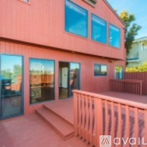 A pink building with a balcony and a window.