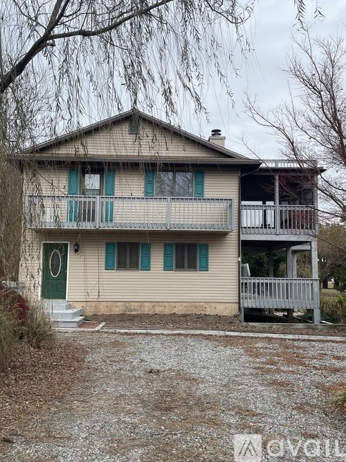 A two-story house with a balcony and a green door.
