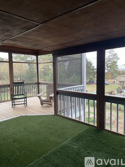 A balcony with a wooden floor and glass railings.
