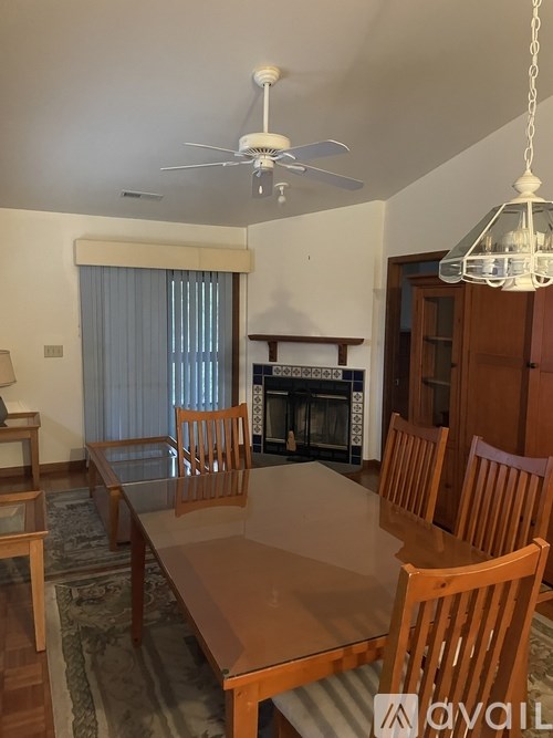 A living room with a fireplace and a dining table.